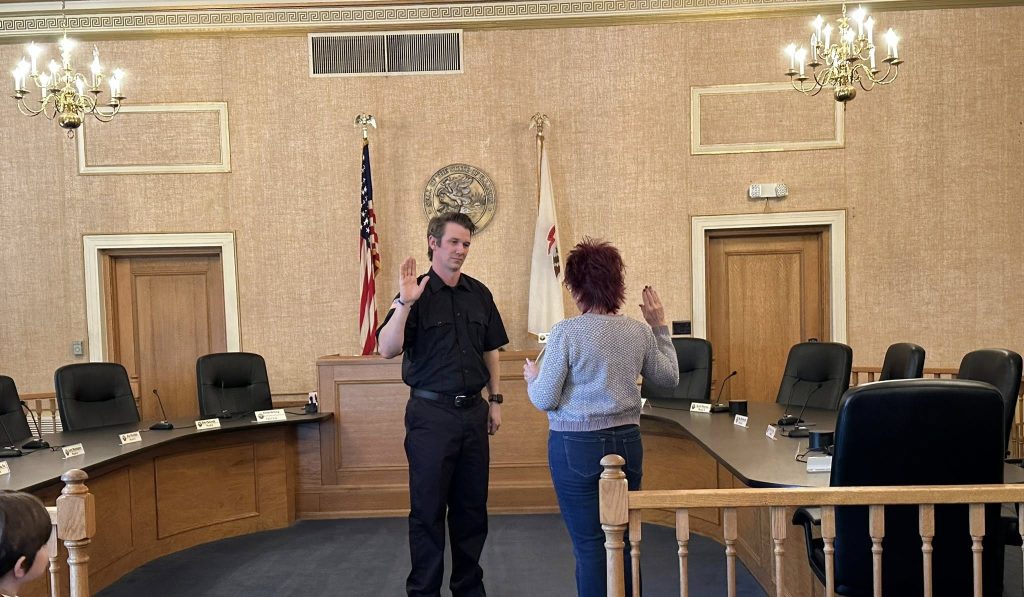 Firefighter Andrew Clark being sworn in by City Clerk Jenna DeYong